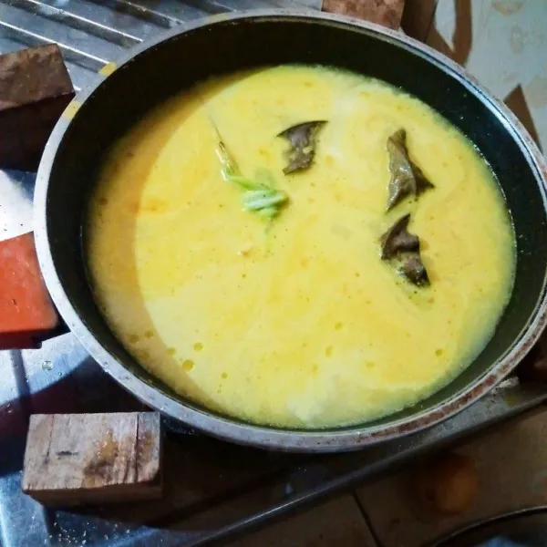 Masukkan serai, daun salam, gula, dan garam. Aduk sebentar kemudian masukkan air santan. masak sambil diaduk agar santan tidak pecah. Masak dan aduk terus hingga mendidih.