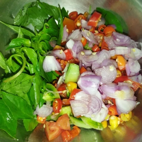 siapkan mangkuk, masukkan daun kemangi, irisan bawang merah, cabe rawit, tomat merah dan juga tomat hijau.