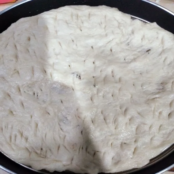 Letakkan kulit pizza diatas sekat kukusan dan letakkan di teflon lalu tusuk-tusuk agar tidak bergelembung.
