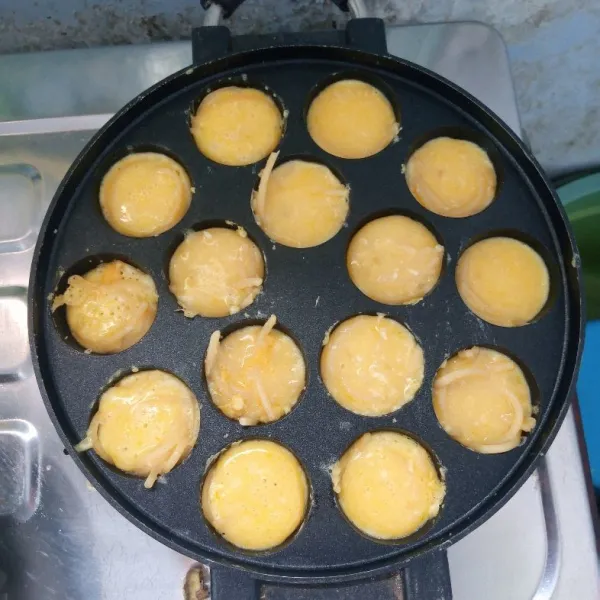 Siapkan cetakan lumpur (takoyaki). Olesi dengan margarin. Tuang secukupnya adonan. Masak sampai setengah matang.