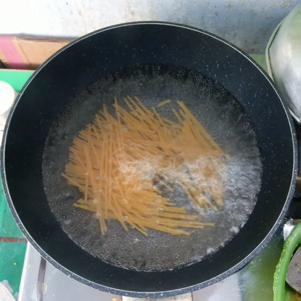 Potong-potong spaghetti. Kemudian rebus sampai matang dan empuk.