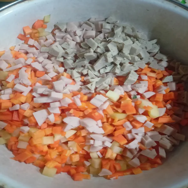 Potong-potong dadu ukuran kecil wortel, kentang, bakso, dan sosis.
