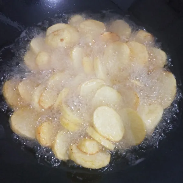 Kupas kentang, kemudian cuci bersih. Potong setebal 1/2 cm, lalu goreng hingga matang. Angkat, kemudian tiriskan.