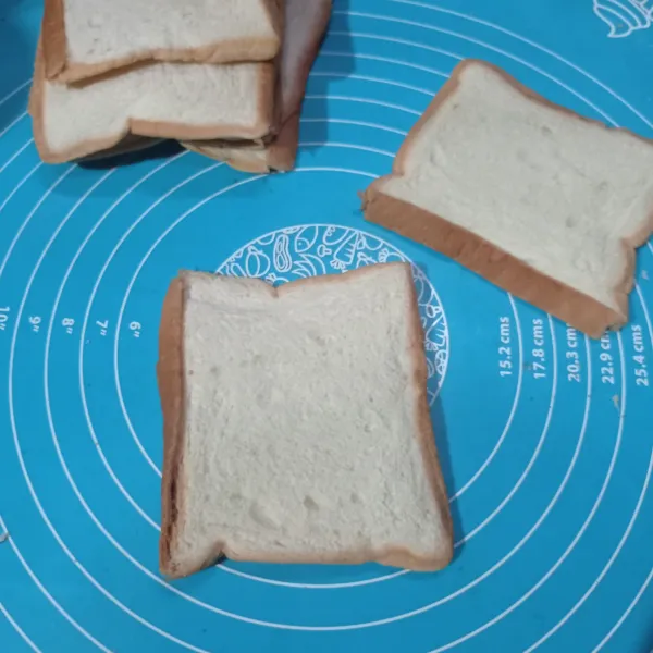 Gilas semua roti tawar menggunakan rolling pin hingga pipih.