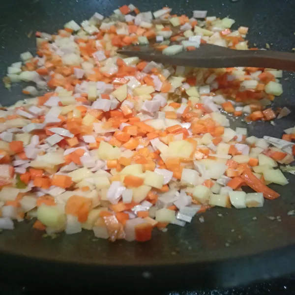 Masukkan kentang, wortel, bakso dan sosis kedalam tumisan bumbu. Aduk-aduk hingga bumbu merata.