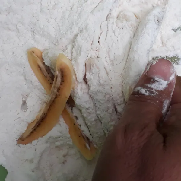 Masukkan potongan pisang ke dalam tepung pelapis lalu aduk-aduk ringan hingga pisang terbalut tepung.