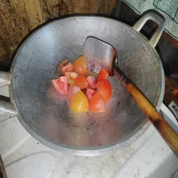 Panaskan sedikit minyak, lalu goreng tomatnya terlebih dahulu hingga agak lembek