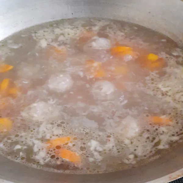 Masukan wortel dan bakso, beri lada, garam dan kaldu bubuk, masak sampai wortel setengah matang.