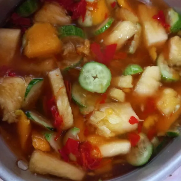 Masukkan buah ke dalam panci berisi kuah asinan, aduk merata