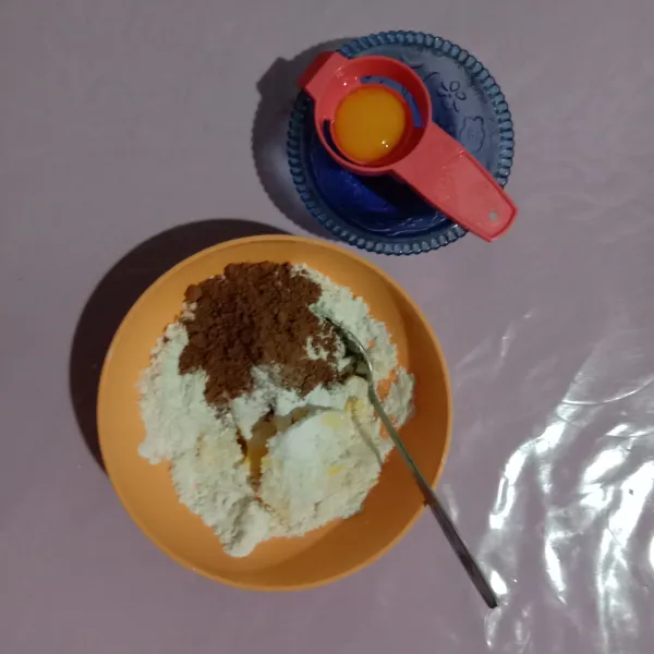 Siapkan bahan topping masukkan semua bahan ke wadah kecuali kuning telur. Aduk rata hingga bertekstur crumble (butiran kecil). Masukkan kuning telur aduk hingga rata dan sisihkan.