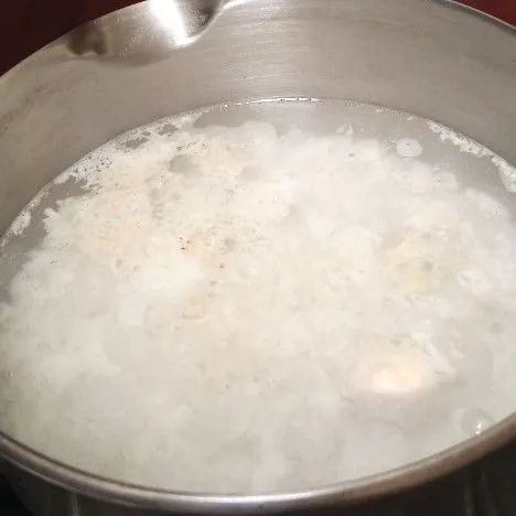 Masukkan nasi ke panci berisi air.