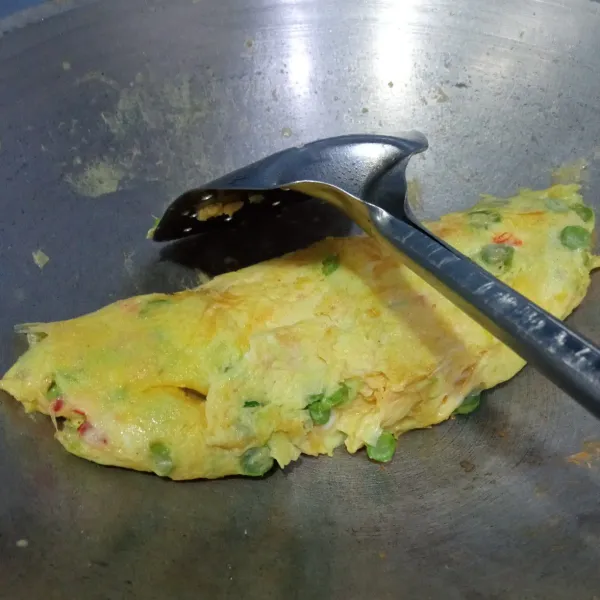 Gulung telur perlahan, masak hingga telur matang, balikkan sisi lainnya.