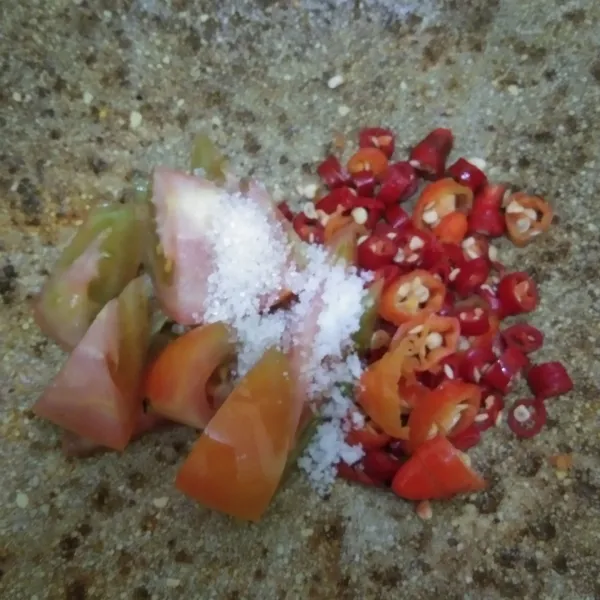 Haluskan cabai merah keriting, cabai rawit dan tomat, agak kasar saja jangan sampai terlalu halus, sisihkan.
