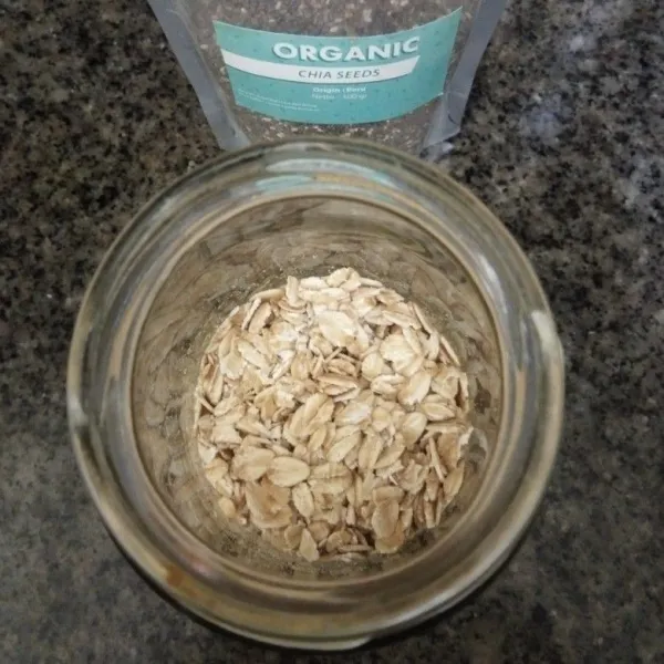 Siapkan jar, tuang rolled oats ke dalamnya.