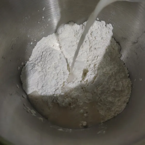 Tuang larutan ragi gula ke adonan kering. Aduk rata lalu uleni hingga kalis, lebih mudah dan cepat pakai mixer ulir dengan kecepatan 4.