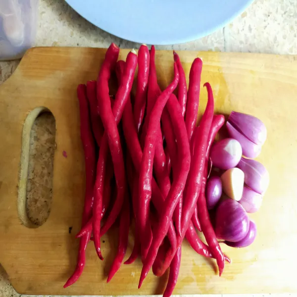 Siapkan cabai merah keriting dan bawang merah, lalu haluskan.