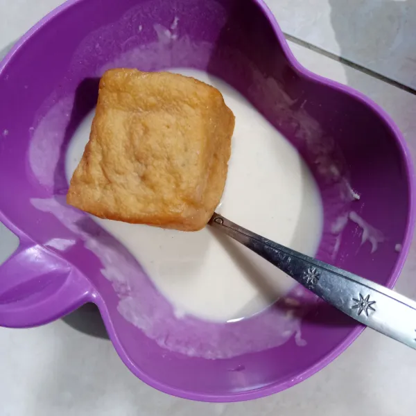 Aduk rata tepung bumbu dan maizena. Ambil 3 sdm tepung lalu beri air secukupnya, aduk rata (adonan encer). Masukkan tahu dalam tepung basah.