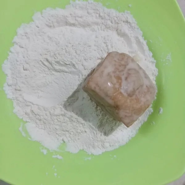 Gulingkan tahu dalam tepung kering. Celup dalam tepung basah sekali lagi lalu tepung kering.