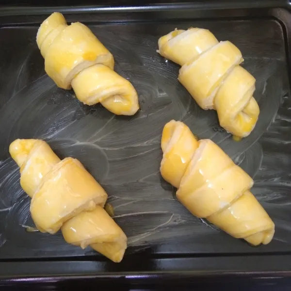 Siapkan loyang yang telah di olesi margarin, tata gulungan croissant, olesi permukaannya dengan kuning telur, panggang dengan suhu 180°C hingga matang, atau sesuaikan dengan oven masing-masing.