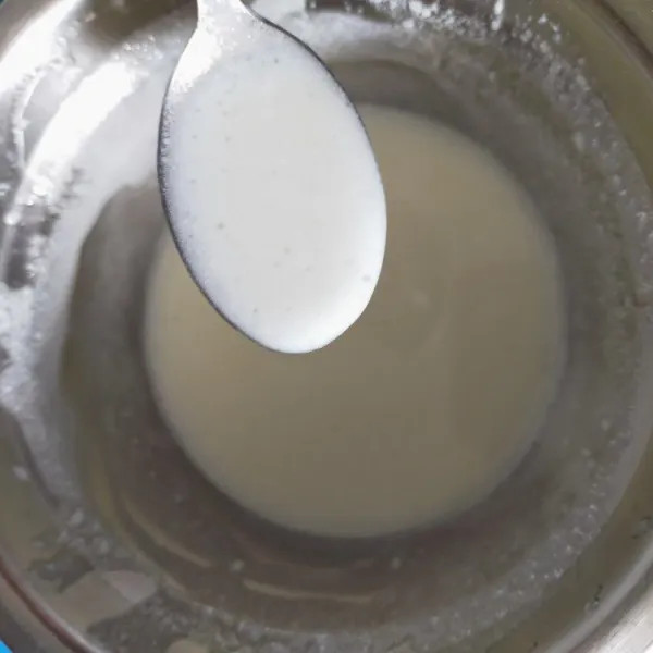 Dalam wadah lain, aduk rata minyak dan susu sampai berwarna putih kental.