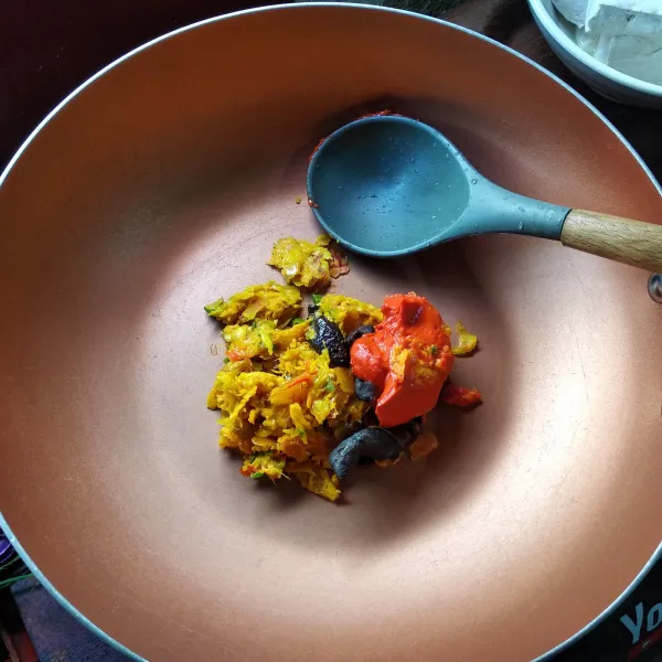 Masukkan ke wajan bumbu yang sudah halus, masukkan cabe giling, daun kunyit dan santan encer. Masak hingga mendidih.