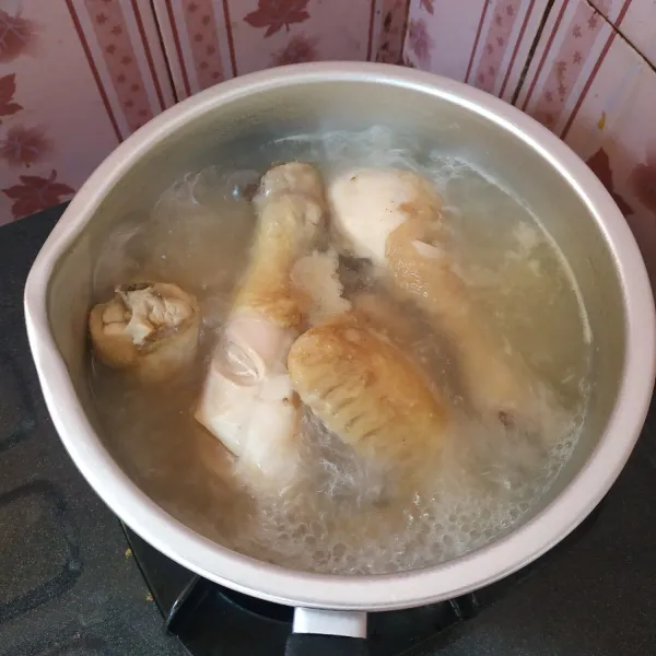 Cuci bersih ayam, kemudian rebus sampai empuk.