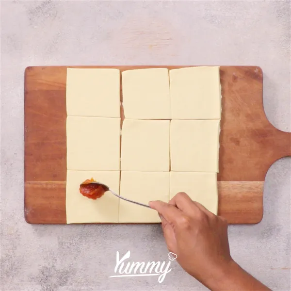 Ambil satu lembar puff pastry lalu isi dengan satu sendok selai nanas.