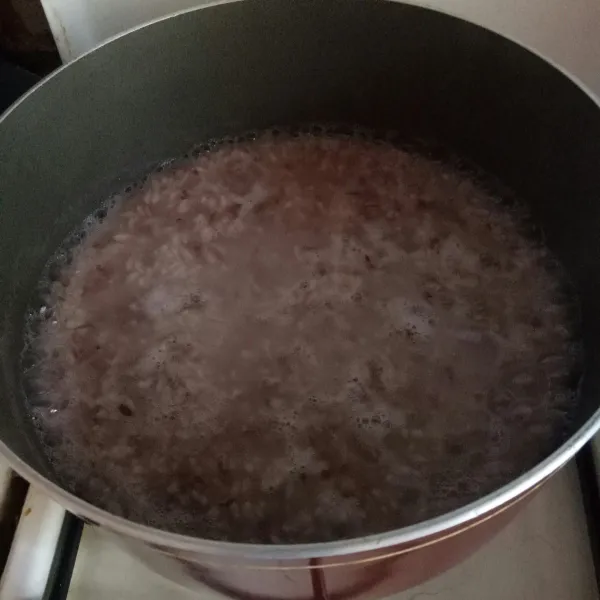Masak air hingga mendidih, masukkan nasi. 
Biarkan nasi menjadi lembek dan agak dingin.