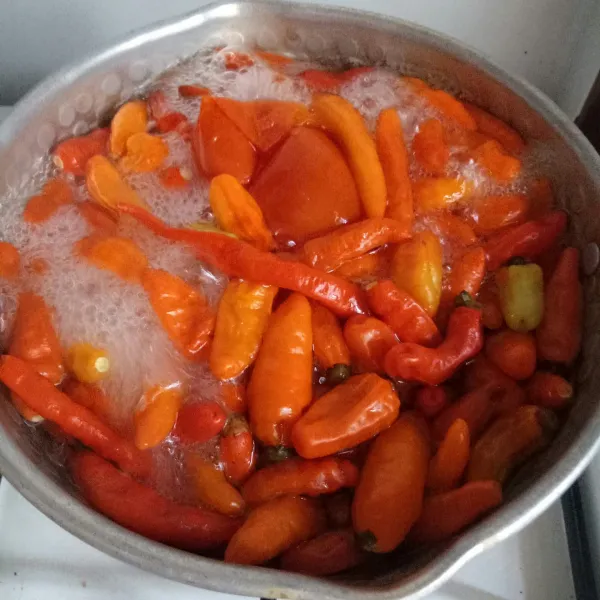 Rebus cabai dan tomat hingga empuk.
