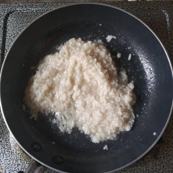 Masak hingga air menyusut dan nasi 3/4 matang, sisihkan.