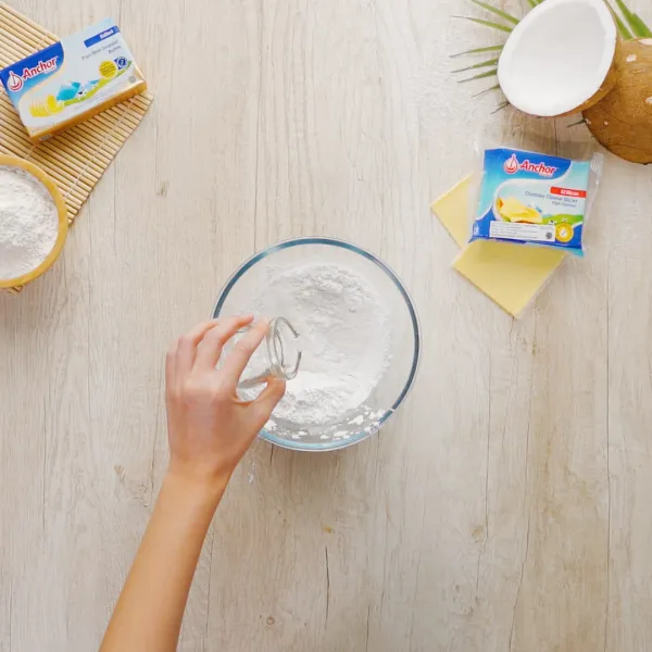 Campurkan tepung beras ketan dan gula halus hingga merata, lalu tambahkan air panas sedikit demi sedikit sambil diaduk hingga tidak lengket dan bisa dibentuk.