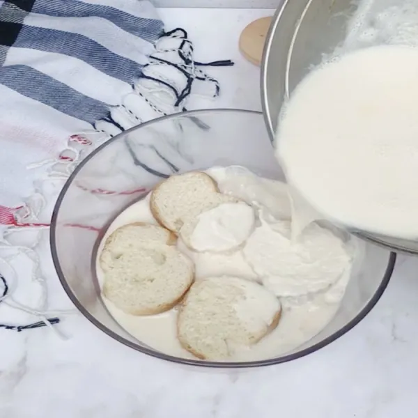 Diamkan susu sampai dingin. Lalu, campurkan dengan roti baguette yang telah dipotong.