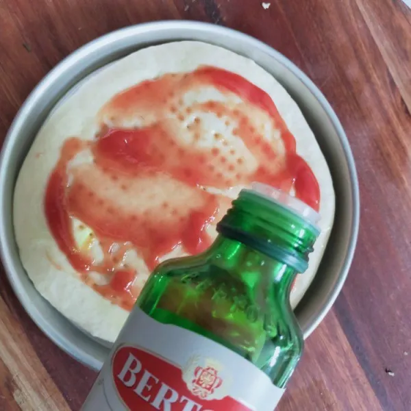 Olesi dengan saus tomat, lalu beri minyak zaitun.