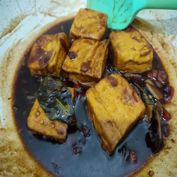 Masak hingga kuah mengental dan menyerap ke dalam tahu. Matikan api. Salin ke piring saji.