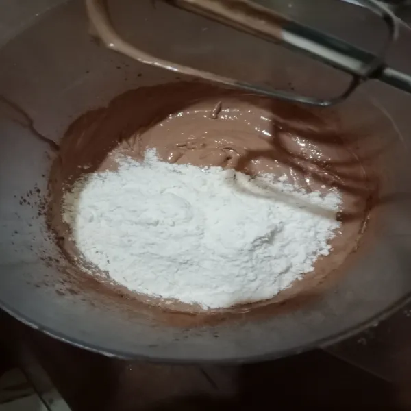 Tambahkan tepung terigu yang sudah di ayak. Kemudian aduk hingga merata.