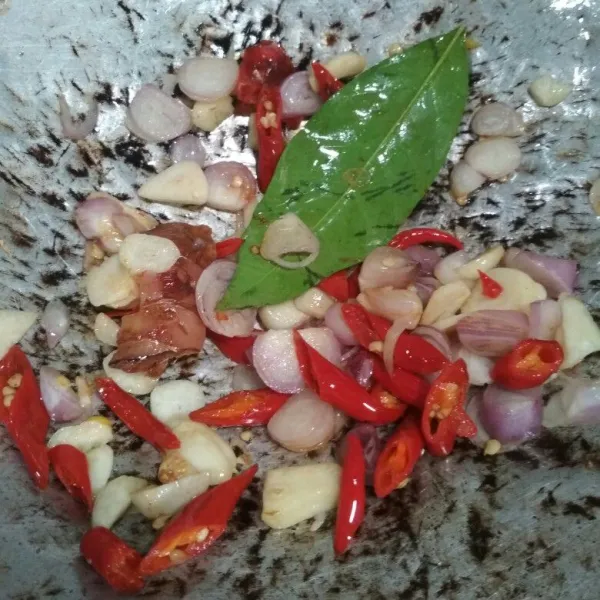 Tumis bawang merah dan bawang putih, tambahkan potongan cabai, daun salam dan lengkuas. Tumis hingga harum.