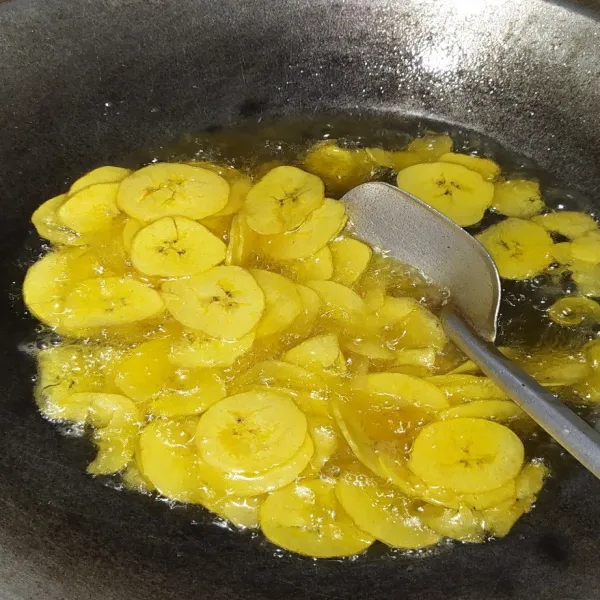 Setelah menteganya cair masukkan irisan pisang, aduk-aduk pelan agar pisangnya tidak lengket satu sama lain.