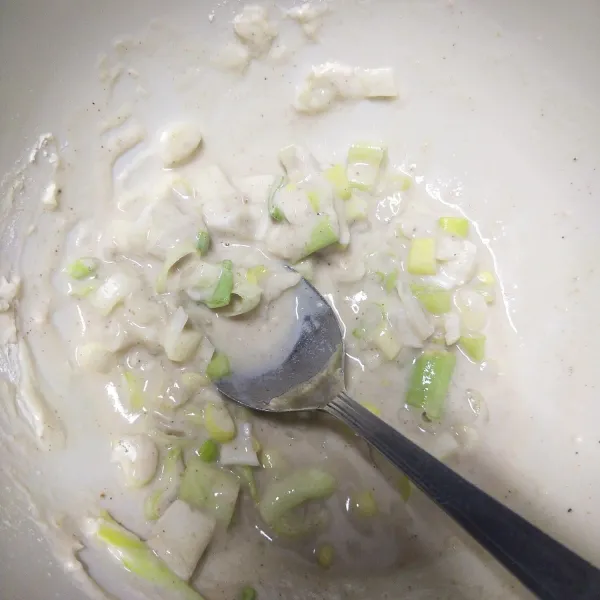 Langkah yang pertama, masukkan tepung terigu, irisan daun bawang, dan air secukupnya. Lalu aduk sampai rata.