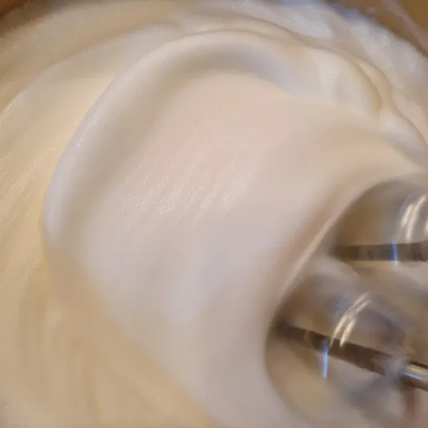 Bahan B mixer putih telur, air lemon dan garam hingga berbusa. Masukkan gula secara bertahap hingga mengembang soft peak.