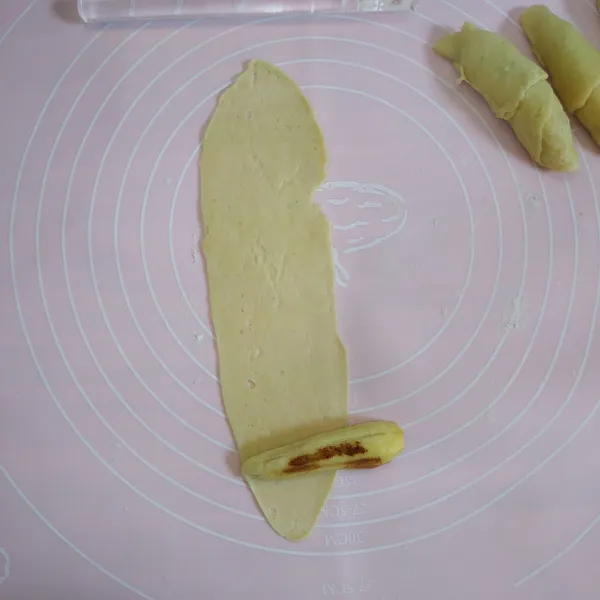 Ambil adonan kulit secukupnya kemudian gilas sampai tipis tambahkan 1 potong pisang kemudian lilitkan.