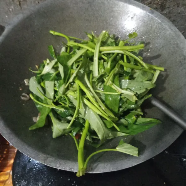 Masukkan kangkung, kemudian besarkan api.