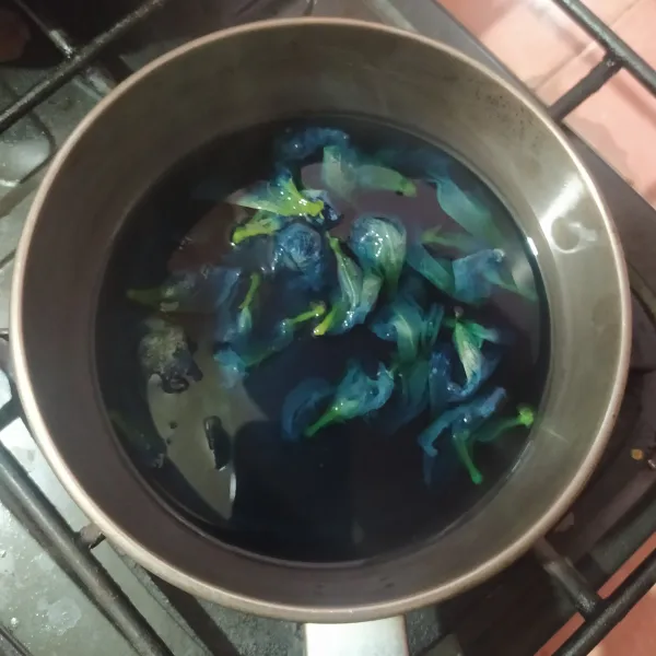 Rebus bunga telang dengan air sampai berubah warnanya menjadi biru. Saring dan takar airnya sebanyak 500 ml.