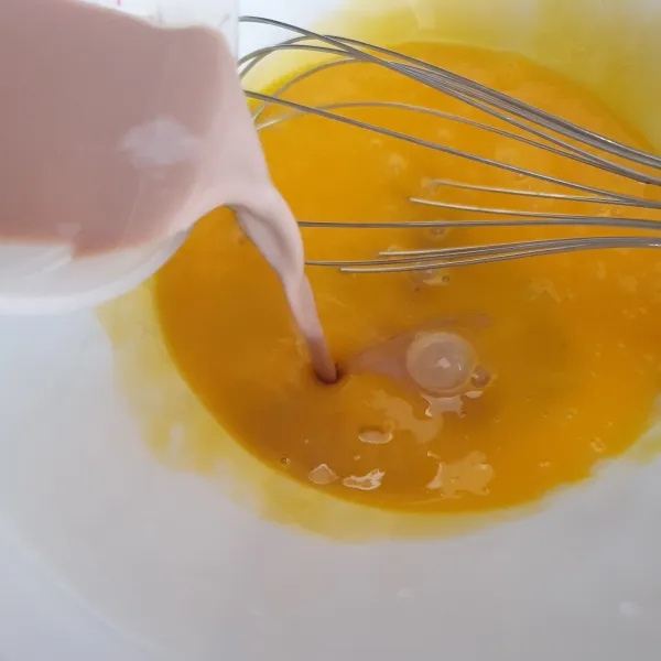 Aduk menggunakan whisk kuning telur, tambahkan susu cair dan minyak hingga tercampur.Aduk perlahan. Tambahkan pasta coklat.