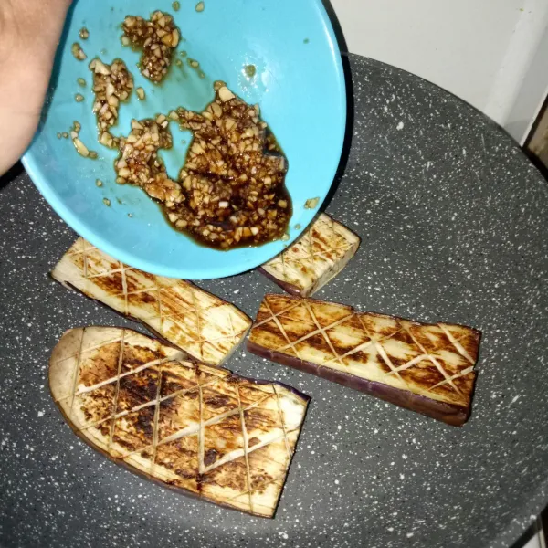Tuangkan bumbu yang telah diaduk rata pada bagian atas terong yang telah di kerat sebelumnya.