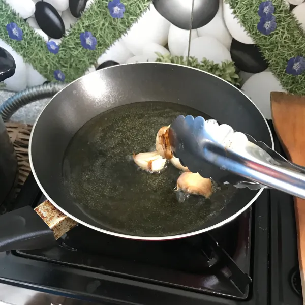 Tumis bawang putih dalam minyak panas hingga matang, lalu sisihkan.