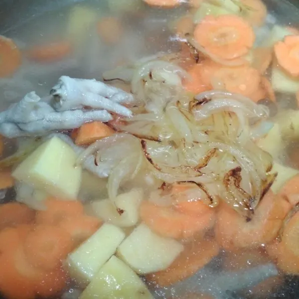 Didihkan air yang baru, ceker ayam, potongan kentang, potongan wortel tambahkan bawang bombay yang sudah ditumis tadi, masukkan bawang putih yang sudah digeprek, masak hingga wortel dan kentang empuk