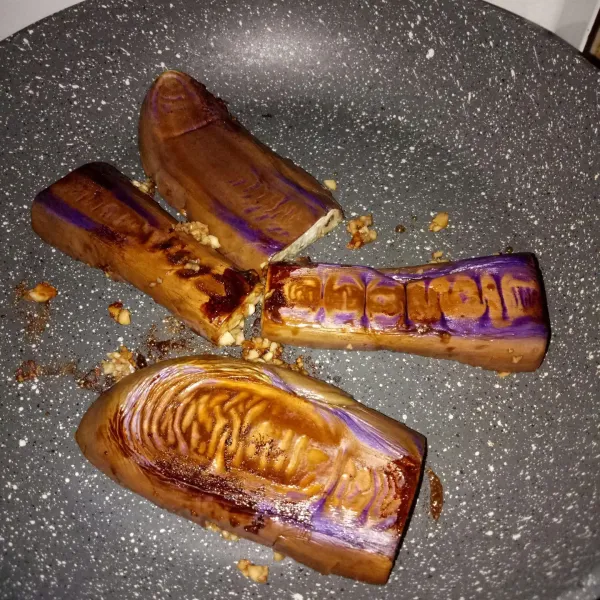 Kemudian balikkan posisi terong agar bumbu meresap sempurna. Setelah matang, angkat dan sajikan dengan taburan daun bawang.