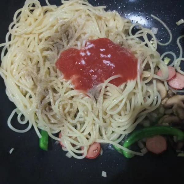 Masukkan spagetti matang, saus tomat, kecap Inggris, garam, dan lada hitam bubuk. Beri sedikit air. Aduk rata. Koreksi rasa.