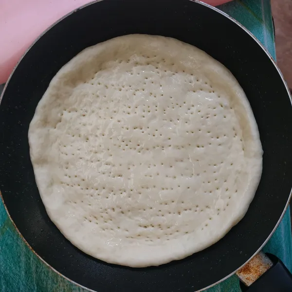 Ambil satu buah adonan pipihkan adonan di atas teflon yang sudah diolesi margarin, tusuk-tusuk dengan garpu lalu olesi dengan minyak goreng di atasnya.