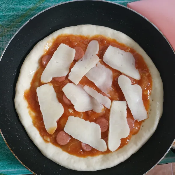 Tambahkan sosis dan taburi dengan keju mozzarella.